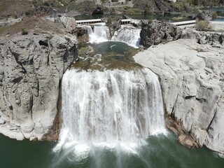 Vertical shot of raging waterfalls surrounded by rocks