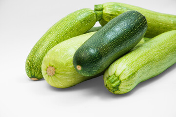 fresh zucchini on a white background. delicious green vegetables on the table. appetizing zucchini on a light texture. healthy food concept