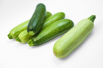 fresh zucchini on a white background. delicious green vegetables on the table. appetizing zucchini on a light texture. healthy food concept