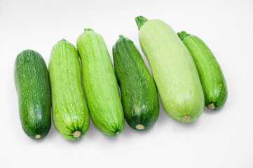 fresh zucchini on a white background. delicious green vegetables on the table. appetizing zucchini on a light texture. healthy food concept