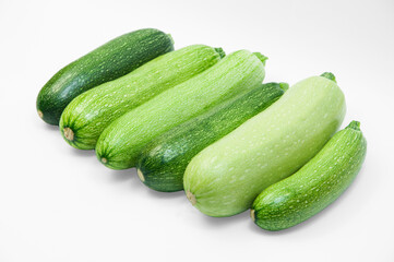 fresh zucchini on a white background. delicious green vegetables on the table. appetizing zucchini on a light texture. healthy food concept
