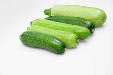 fresh zucchini on a white background. delicious green vegetables on the table. appetizing zucchini on a light texture. healthy food concept