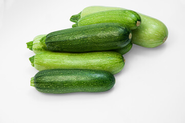 fresh zucchini on a white background. delicious green vegetables on the table. appetizing zucchini on a light texture. healthy food concept