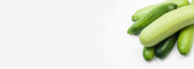 fresh zucchini on a white background. delicious green vegetables on the table. appetizing zucchini on a light texture. healthy food concept