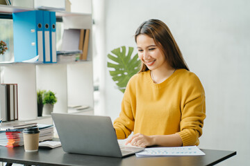 Asian business woman have the joy of talking on the phone, laptop and tablet on the office desk