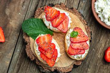 Crostini or toasts with strawberries and cream cheese ricotta. Delicious breakfast or snack, Clean eating, dieting, vegan food concept. top view