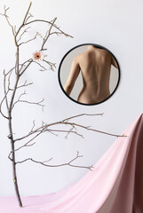 Tender, slim female body, back on mirror reflection. Home interior background. Body art, aesthetics.