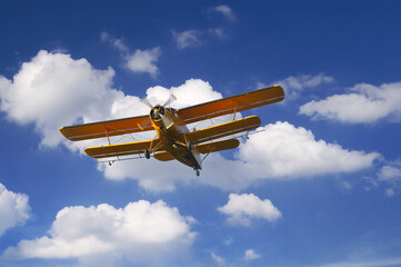 Agricultural airplane spraying pesticides on agricultural fields in summer