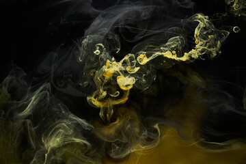 Liquid fluid art abstract background. Black, yellow dancing acrylic paints underwater, space smoke...