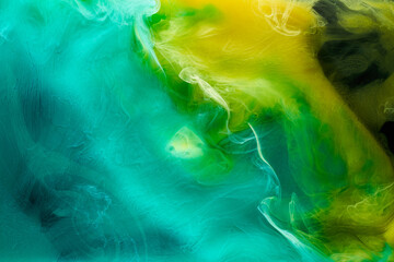 Liquid fluid art abstract background. Green, yellow dancing acrylic paints underwater, space smoke...