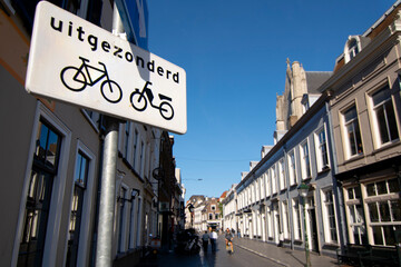 Obraz premium Cityscape small northern european city. Street with small old houses and signage for bicycles on the street. Breda, the Netherlands