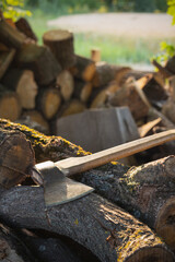 The ax lies on the logs. Outdoors