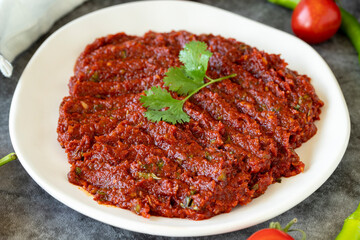 Adjika or chili paste. Hot chili peppers harissa sauce. Spicy paste appetizer on a dark background. close up