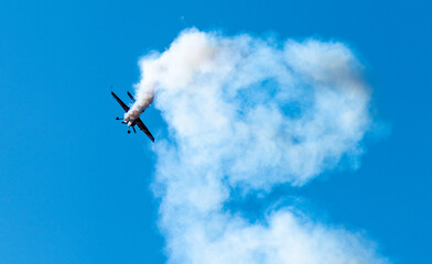 Silhouettes of training aircraft performing aerobatics on a clear sunny day.