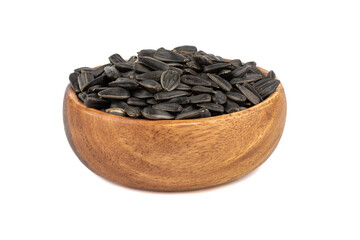 Wooden bowl full of unpeeled sunflower seeds on a white background.