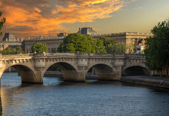 Fototapeta premium The Pont Neuf over the Seine river in the French city of Paris and under a beautiful sunset. Paris is divided by the Seine river and this beautiful European city is full of beautiful bridges.