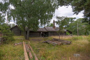 Fototapeta na wymiar Old farm log houses in a forest park, a sunny summer day in Stockholm