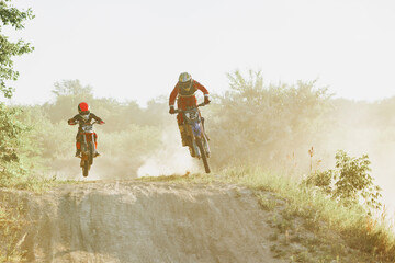Professional and junior sportsmen, motorcyclist training on motorbike at hot summer day, outdoors. Motocross rider in action. Motocross sport, challenges © master1305