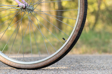 Close up view of cropped bicycle wheel on the road with green naturelan enviroment in the blurred background