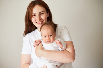 Mother holding her newborn baby. Home portrait of newborn baby and mother. Enjoying time together