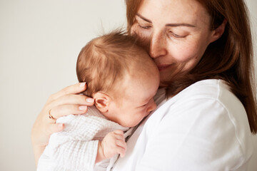 Mother holding her newborn baby. Home portrait of newborn baby and mother. Enjoying time together