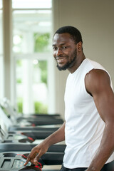 Fototapeta na wymiar African american male try to workout on treadmill in sport club for health and wellbeing life concept