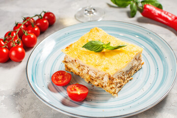 Delicious homemade italian Lasagna with bachamel sauce and glasses of wine on concrete background