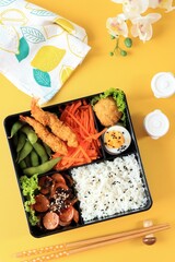 apanese Bento Lunchbox with Steamed Vegetable, Boiled Egg, Nugget, Sausage, Edamame, and Tempura