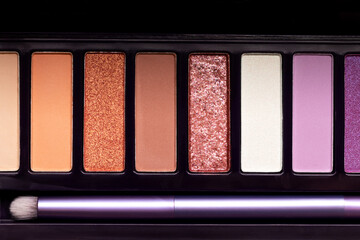 Colorful eye shadow palette background. Color eyeshadow palette with brush for day and evening eye makeup with matte and shimmer shadows