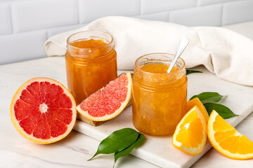 Orange jam in glass jar at white table. preserves for winter