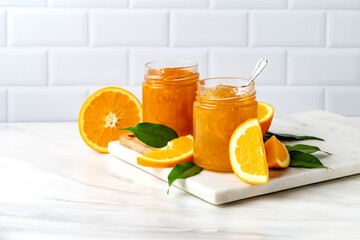 Orange jam in glass jar at white table. preserves for winter