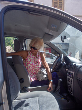 Woman As Driver Looking For Something In The Back Seat In A Car