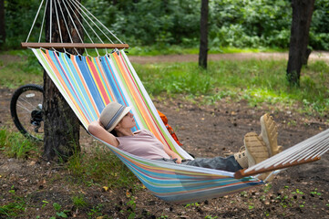 Caucasian woman lies in a hammock in a pine forest