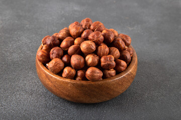 Top view of a bowl full of hazelnuts on dark background
