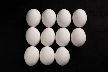 Chicken white eggs on a black background. Farm products. Natural eggs. Chicken eggs on the table