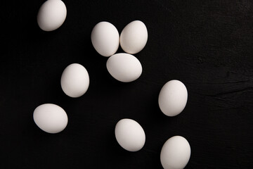 Chicken white eggs on a black background. Farm products. Natural eggs. Chicken eggs on the table