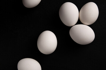 Chicken white eggs on a black background. Farm products. Natural eggs. Chicken eggs on the table
