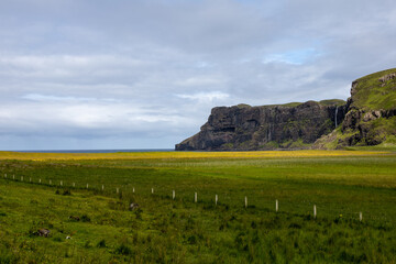Wide angle views of Talisker Bay, Isle of Skye, Scotland, with its rocky beach, black stones, green...