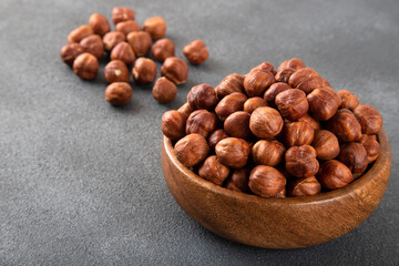 Top view of a bowl full of hazelnuts on dark background
