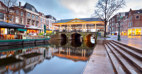 Beautiful old houses on the city embankment of Leiden at sunset.