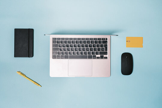 Laptop, mouse, bank credit card on a blue background