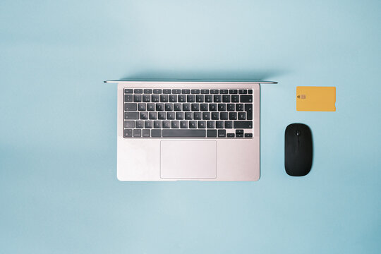 Laptop, mouse, bank credit card on a blue background