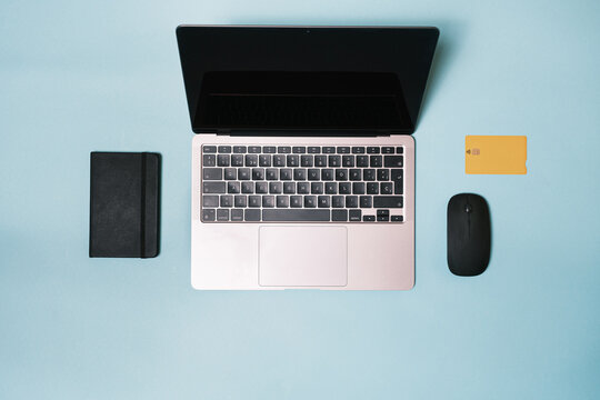 Laptop, mouse, bank credit card on a blue background