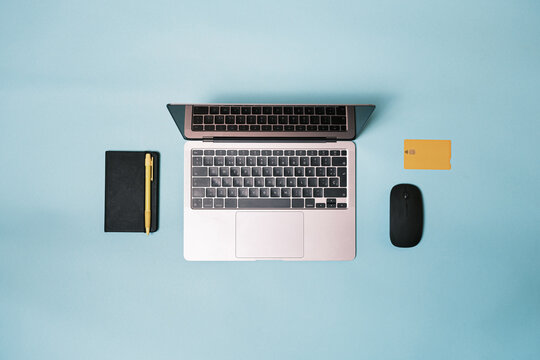 Laptop, mouse, bank credit card on a blue background