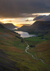 View of Buttermere and Crummock Water taken from high up in mountains with golden sunlight breaking...