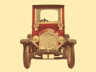 Retro styled image of a cute vintage metal toy car with a sepia background