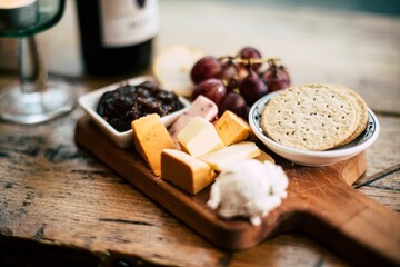 Angle view of vegan appetizers and snacks on a wooden board with blurred background.