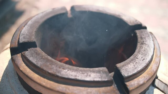 tandoor. Burning wood inside tandoor. Preheat the tandoor before preparing the kebab. cooking meat in the tandoor.
