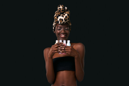 Black girl holding and looking at nail polishes