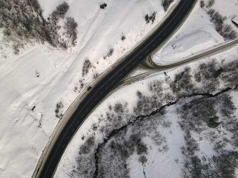 Aerial Shot Of A Highway Road In Between Snowy Hills And Trees, Ukraine